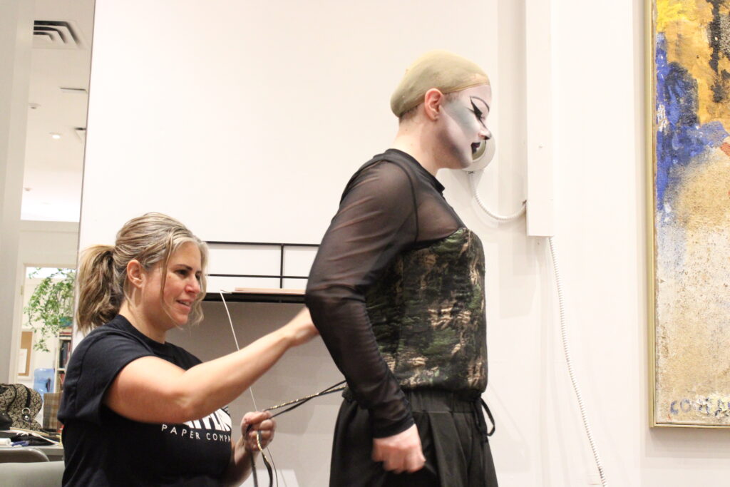 Goyette gets laced into their bustier by their instructor, Renee Berezowski